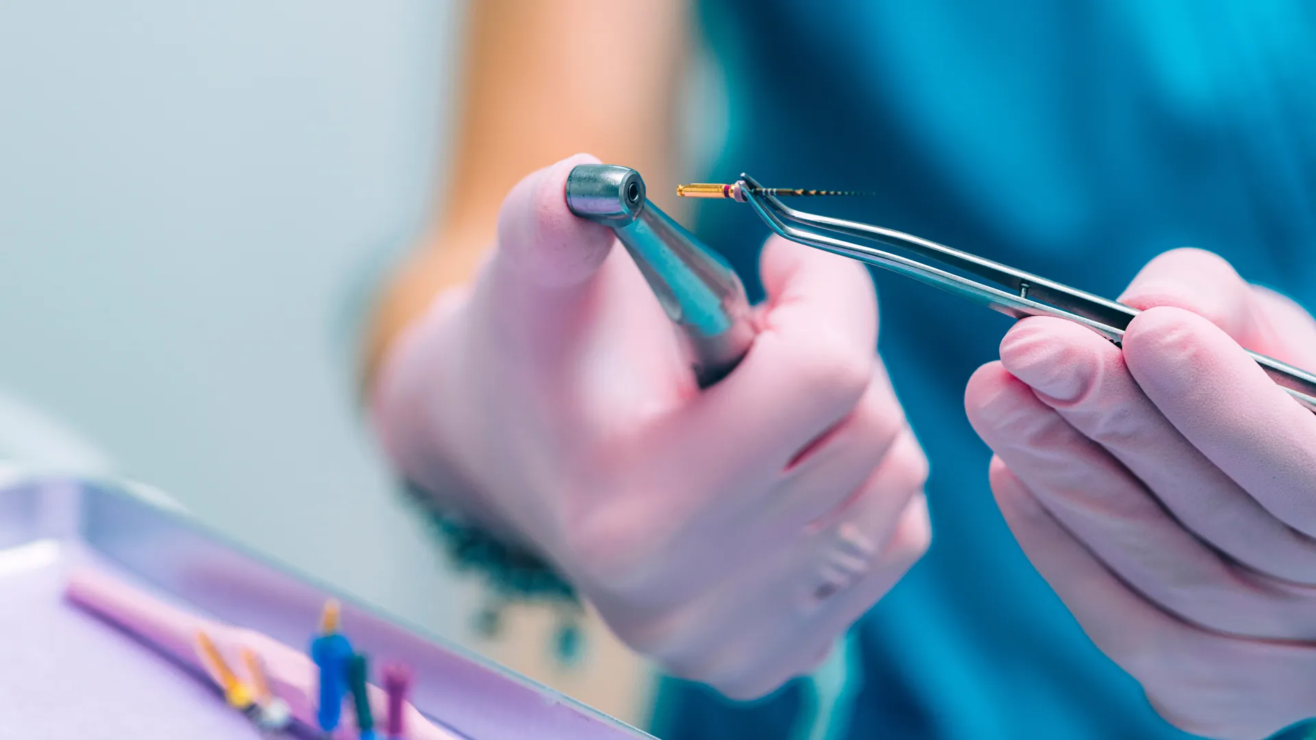Gloved hands preparing instruments for root canal treatment